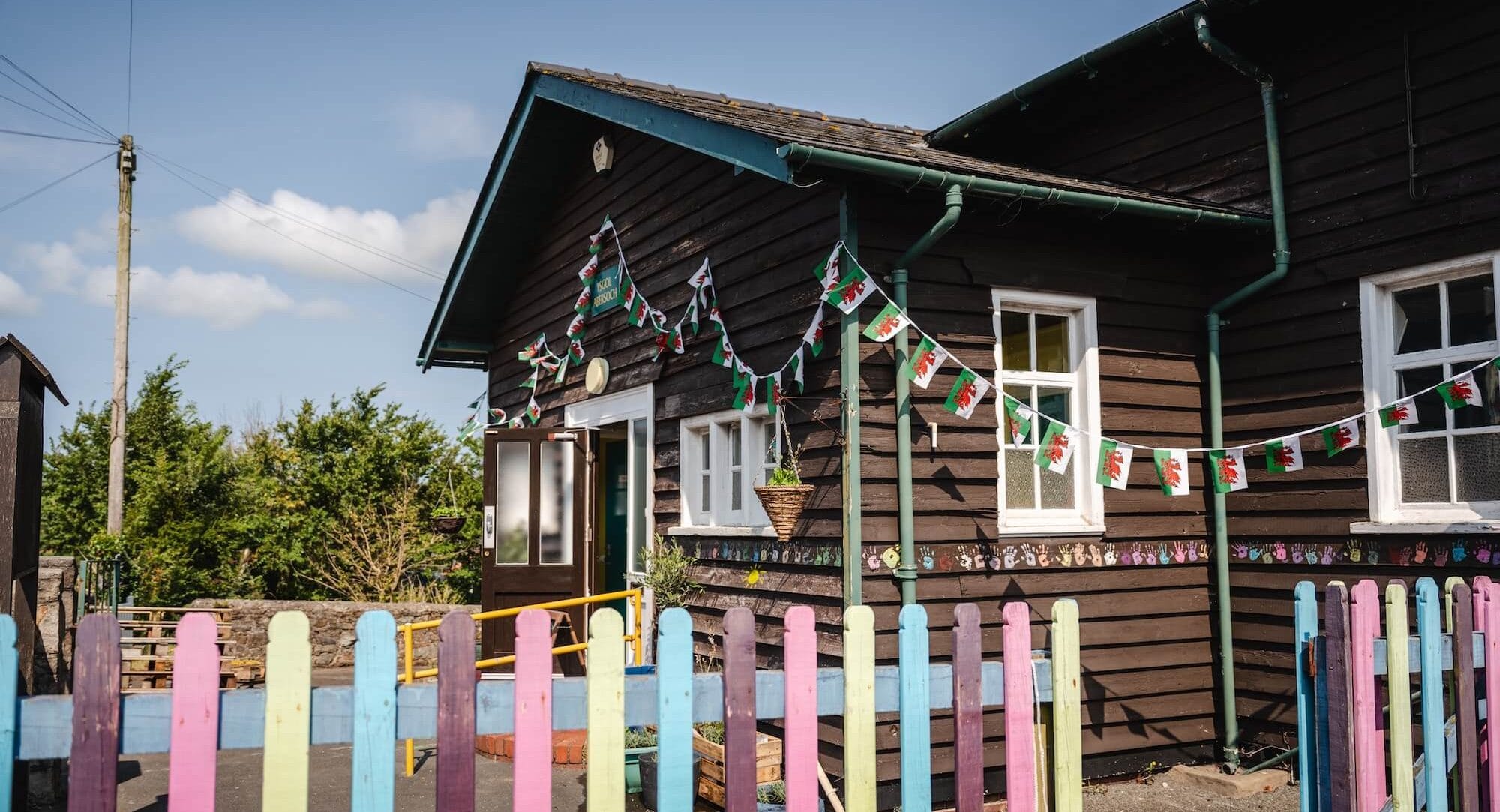 Front of Abersoch old school with colourful fence
